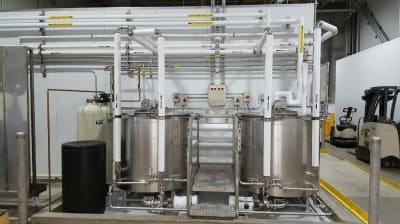 Row of stainless steel batch tanks installed in a plant