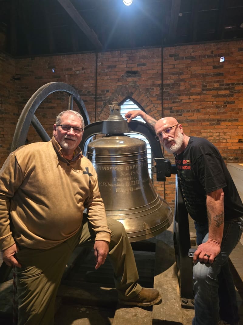 Mike Fleeman and Tim Foster beside the restored bell in the tower