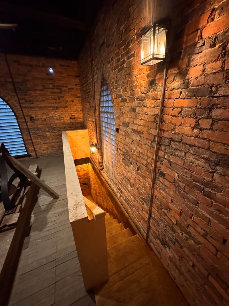 Brick tower wall with new wall light above the stair