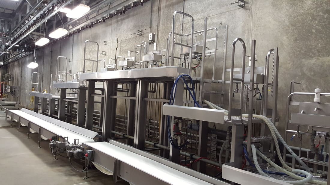 Stainless product dumper beside a processing line