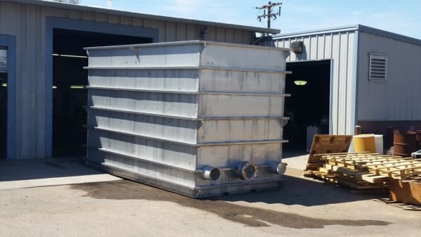 Large stainless condenser sump tank outside the fabrication shop